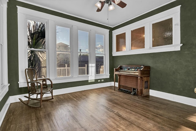 interior space featuring dark hardwood / wood-style flooring, ceiling fan, and ornamental molding