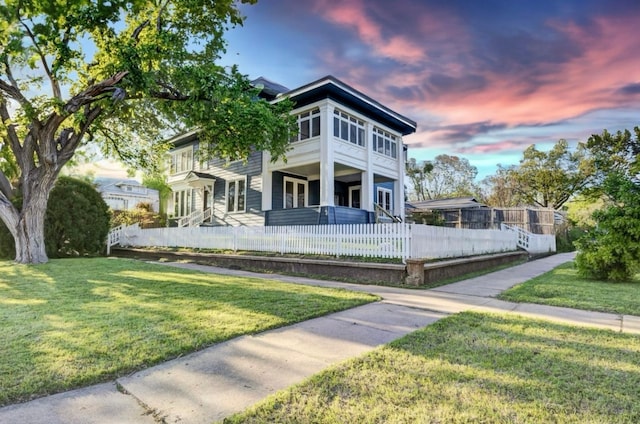 view of front facade featuring a lawn and a balcony