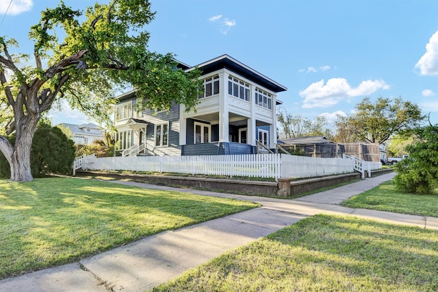 view of front of house featuring a balcony and a front yard