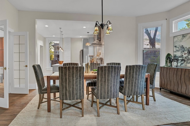 dining room with an inviting chandelier and dark wood-type flooring