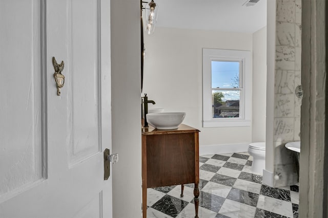 bathroom featuring walk in shower, vanity, toilet, and tile floors