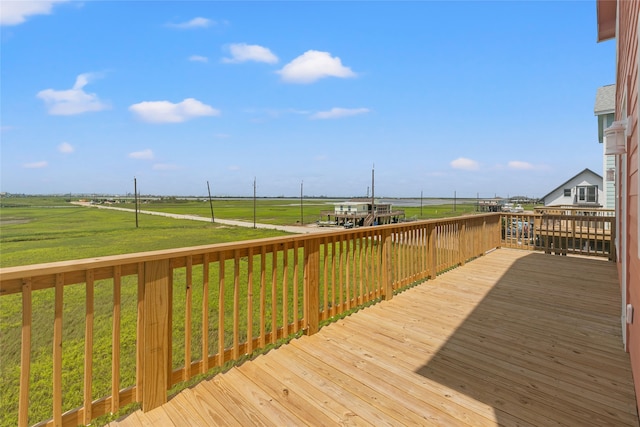 wooden terrace with a lawn and a rural view