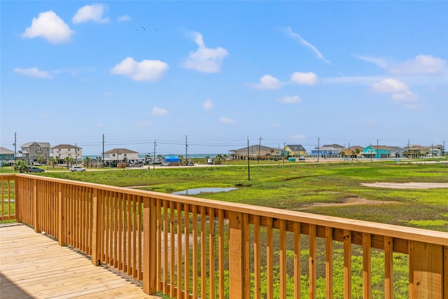 wooden deck with a water view and a yard