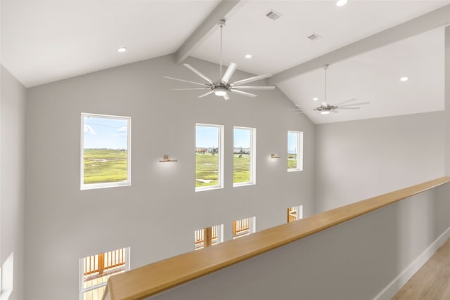 hallway with light wood-type flooring and vaulted ceiling with beams