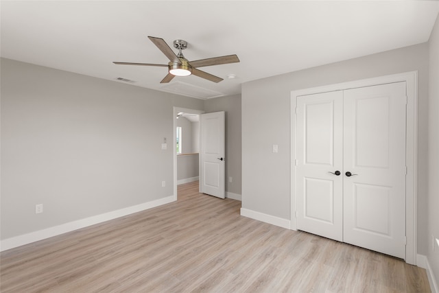 unfurnished bedroom with a closet, light wood-type flooring, and ceiling fan