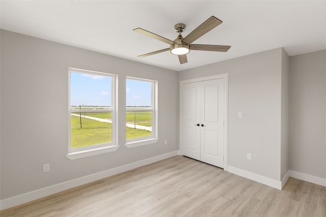 unfurnished bedroom with light hardwood / wood-style flooring, a closet, and ceiling fan