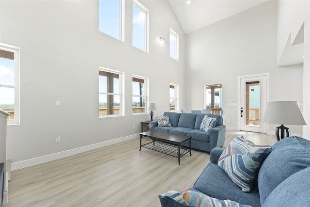 living room with light hardwood / wood-style flooring and high vaulted ceiling