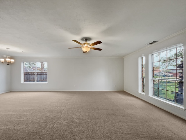 spare room with ceiling fan with notable chandelier, light colored carpet, and a healthy amount of sunlight