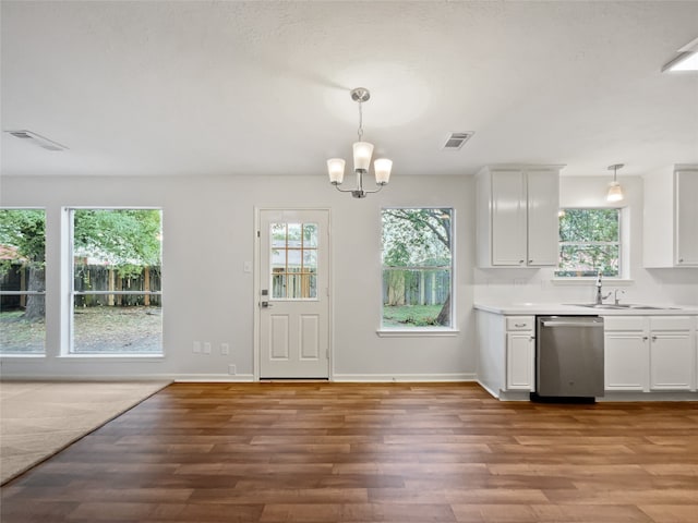 interior space featuring stainless steel dishwasher, decorative light fixtures, light hardwood / wood-style floors, and white cabinets