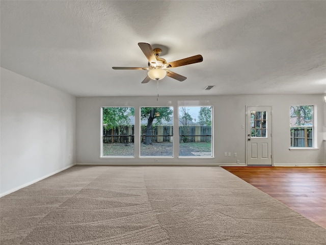 spare room with ceiling fan, light wood-type flooring, and a textured ceiling