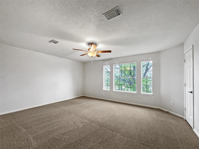 carpeted spare room with ceiling fan and a textured ceiling