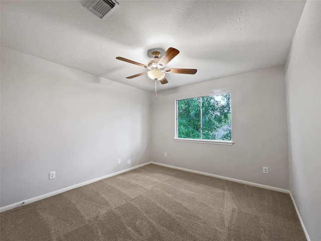 carpeted spare room featuring ceiling fan and a textured ceiling