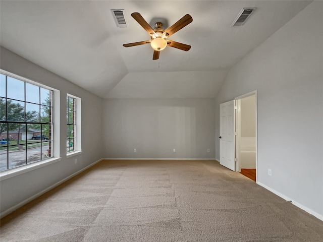 spare room featuring light carpet, ceiling fan, and vaulted ceiling