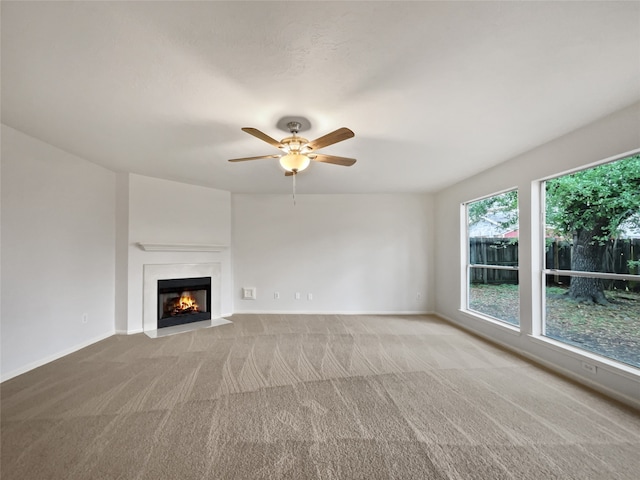 unfurnished living room with ceiling fan and light carpet