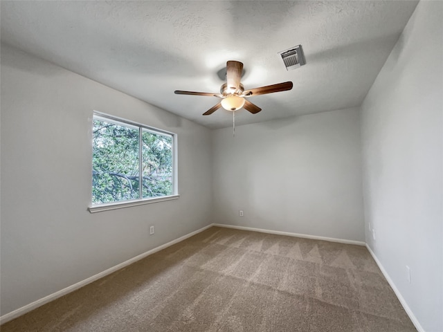 carpeted spare room featuring a textured ceiling and ceiling fan