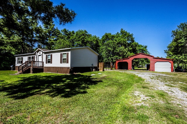 manufactured / mobile home featuring a carport, a front yard, and a garage