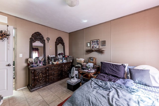 bedroom featuring light tile floors and ornamental molding