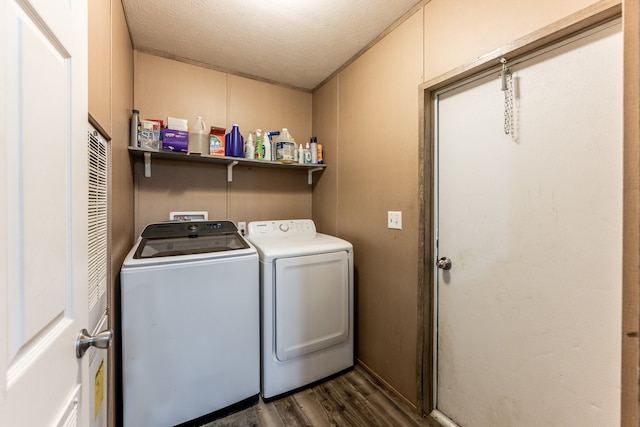 clothes washing area featuring hookup for a washing machine, dark hardwood / wood-style flooring, a textured ceiling, and washer and clothes dryer