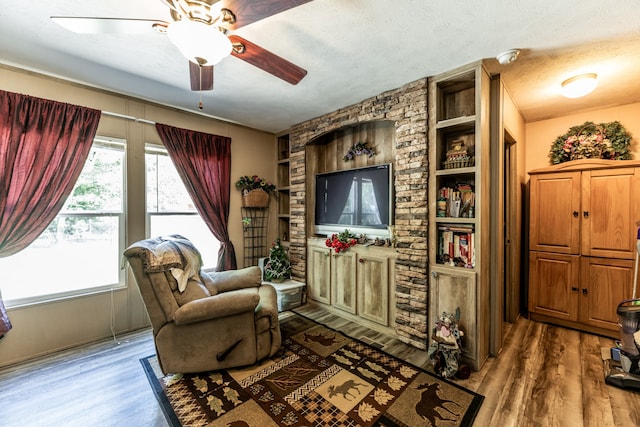 living room featuring dark hardwood / wood-style floors, built in features, a textured ceiling, and ceiling fan