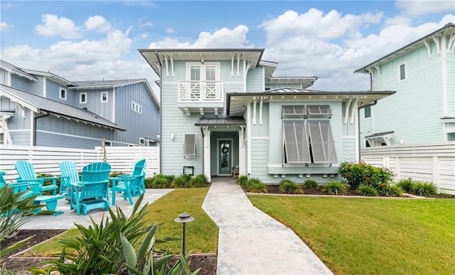 view of front of home featuring a balcony and a front yard