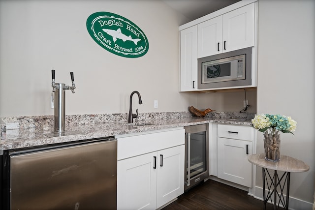 kitchen featuring wine cooler, white cabinetry, stainless steel microwave, dark hardwood / wood-style floors, and sink