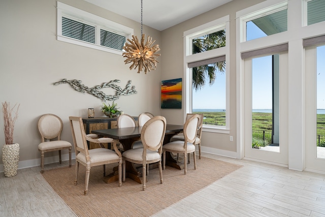 dining area with light hardwood / wood-style floors and a notable chandelier