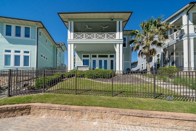 view of front of property featuring a front lawn and a balcony