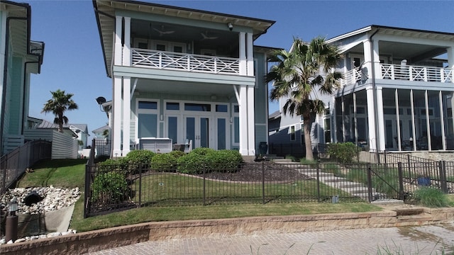 rear view of property featuring a lawn and a balcony