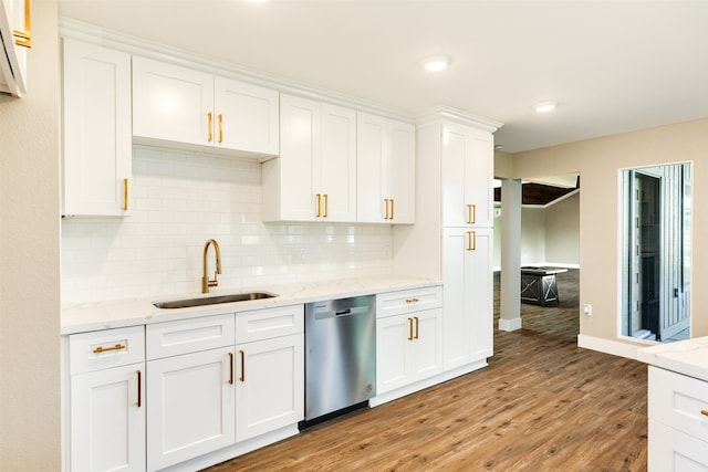 kitchen with backsplash, sink, light wood-type flooring, white cabinets, and dishwasher