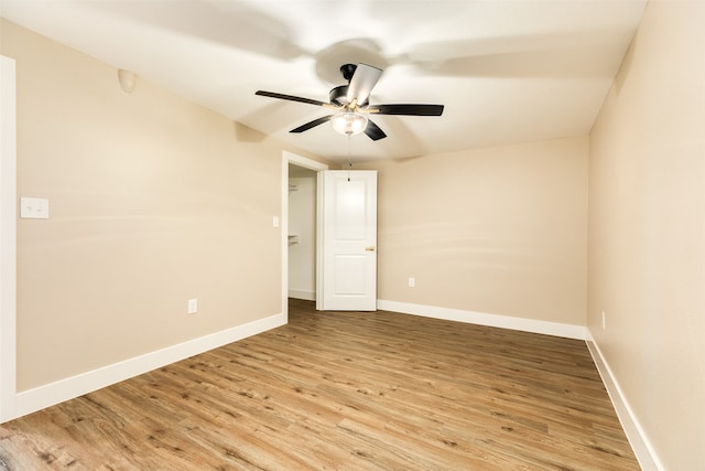 empty room with ceiling fan and light hardwood / wood-style floors