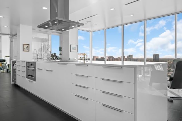 kitchen featuring white cabinetry, a wealth of natural light, dark wood-type flooring, and island range hood