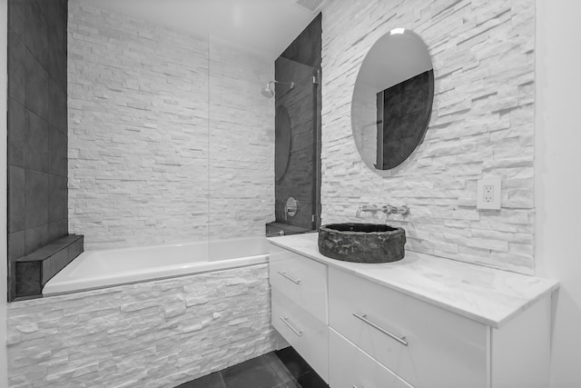 bathroom with vanity, tiled shower / bath combo, and tile floors