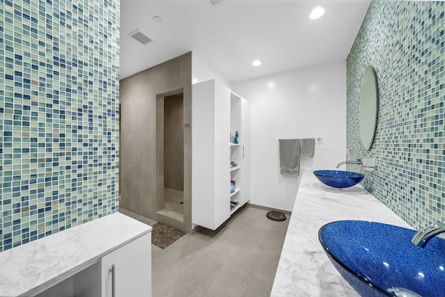 bathroom featuring tile walls, tile flooring, and dual vanity