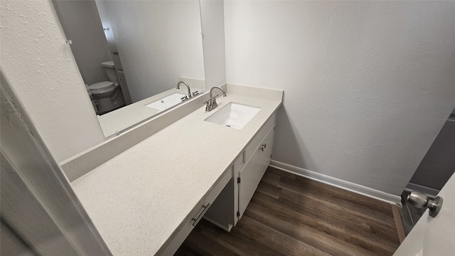 bathroom with vanity, toilet, and hardwood / wood-style floors