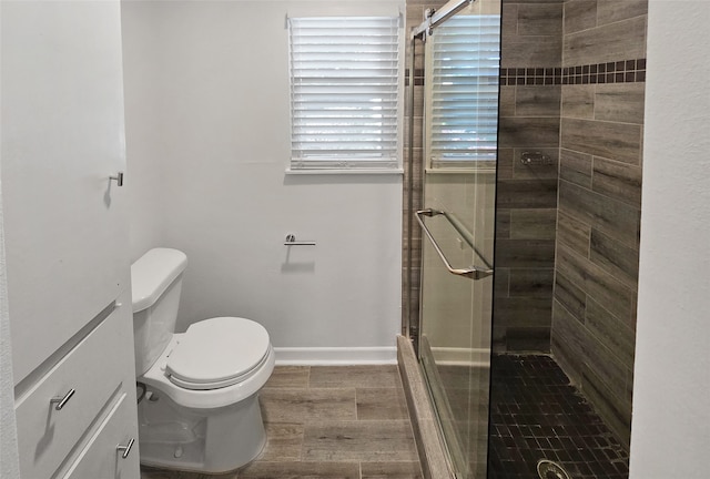 bathroom featuring toilet, a shower with door, and hardwood / wood-style flooring