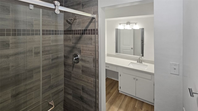 bathroom with walk in shower, wood-type flooring, and vanity