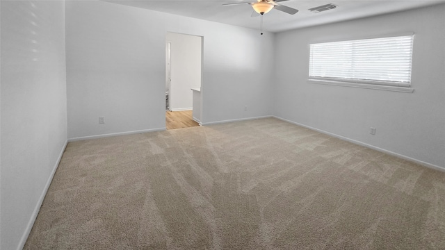 carpeted spare room with ceiling fan