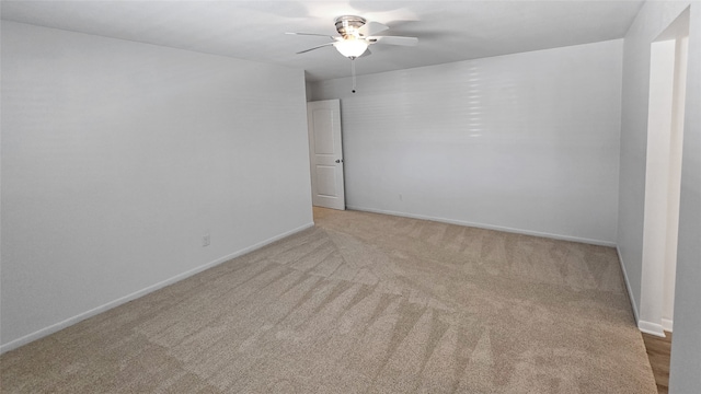 spare room featuring light colored carpet and ceiling fan