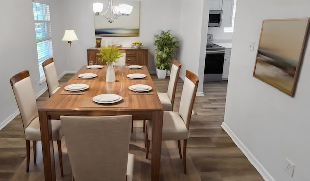 dining space with dark wood-type flooring and a chandelier