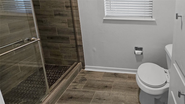 bathroom with toilet, hardwood / wood-style flooring, and walk in shower