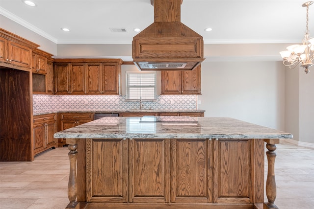 kitchen featuring a center island, pendant lighting, light stone countertops, backsplash, and an inviting chandelier