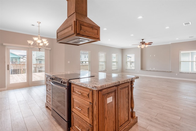 kitchen with plenty of natural light, custom range hood, range with electric cooktop, and a kitchen island