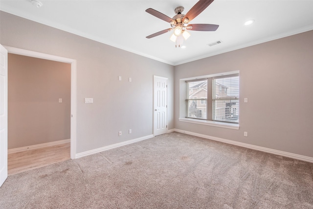 carpeted empty room with ceiling fan and ornamental molding