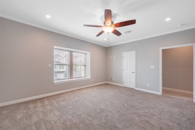 carpeted spare room with ceiling fan and crown molding