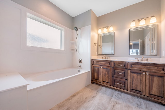 bathroom with hardwood / wood-style floors, large vanity, and double sink