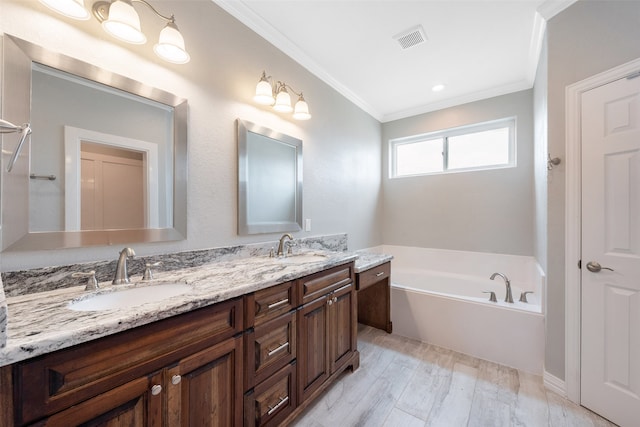 bathroom featuring ornamental molding, a bath, double sink, and large vanity