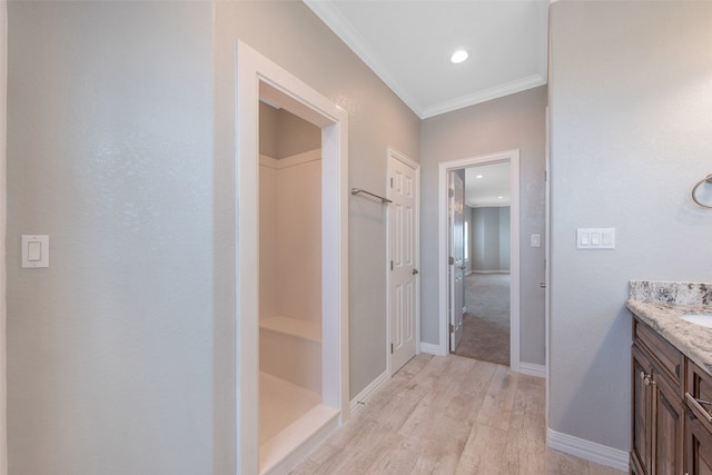 bathroom with vanity, hardwood / wood-style flooring, and crown molding