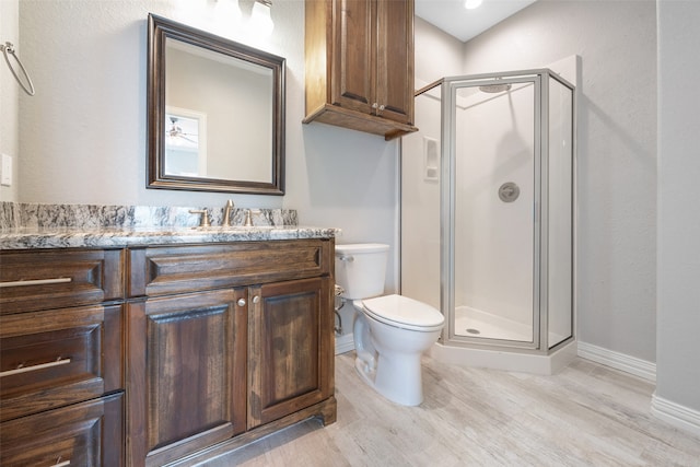 bathroom with vanity, an enclosed shower, toilet, and hardwood / wood-style flooring