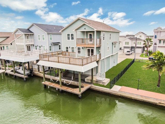 view of dock featuring a yard, a water view, and a balcony