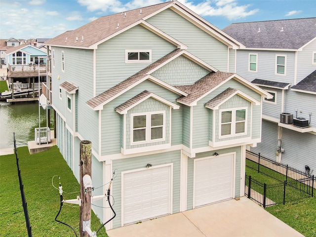 view of front of home featuring a front lawn, a balcony, a garage, and central air condition unit